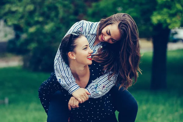 Al aire libre de la joven mujer que lleva a su amiga en su ba — Foto de Stock