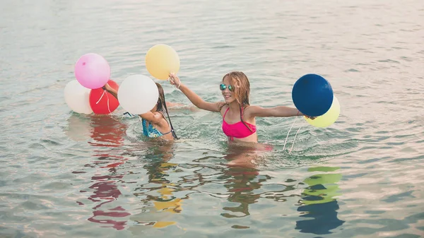 Lyckliga små flickor som kör tillsammans med ballonger genom WA — Stockfoto