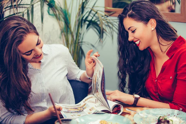 İki güzel genç kadın m okurken birlikte pasta zevk