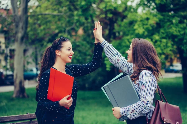 Dos amigas felices, estudiantes están dando choca cinco después de su — Foto de Stock