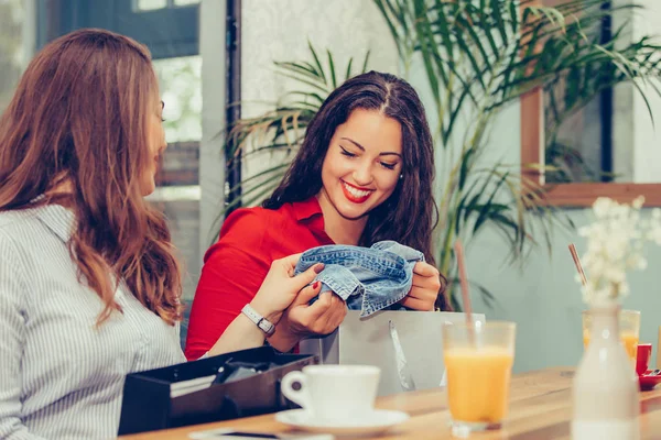 Two young women sharing their new purchases with each other