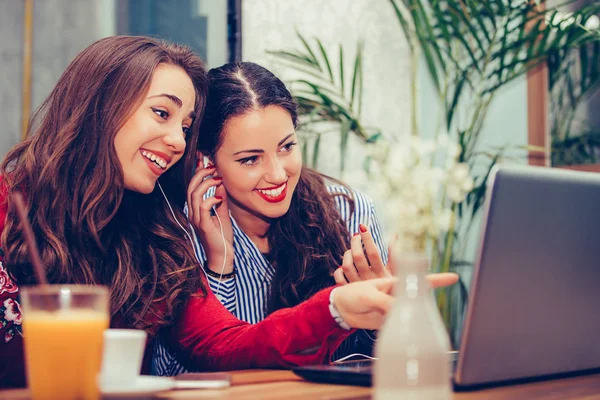 Dizüstü bilgisayarı gösteren genç bir kadın izliyor ve tartışıyor. 