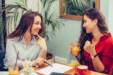 İki mutlu kadın birlikte belgeleri okuyor, nereye si işaret