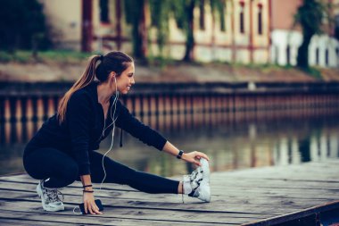 Nehrin yanında germe egzersiz yaparak güzel genç kadın