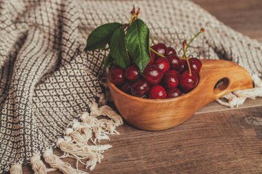 Ahşap kase yeşil yaprakları ile taze kiraz 