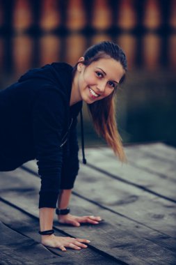 Kız nehir tarafından itme yapıyor, egzersiz için hazırlanıyor