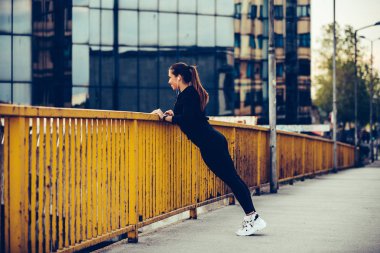 Kız köprüde germe egzersiz yapıyor