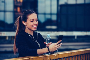 Mutlu genç kadın iş dışarı sonra bir mola almak ve mu dinleme