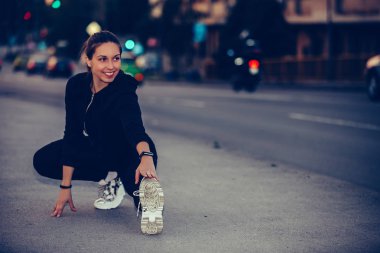 Genç kadın nehir köprüsünde bacaklarını gererek, gece