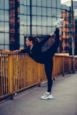 Güzel kız köprüde germe egzersiz yapıyor, gece