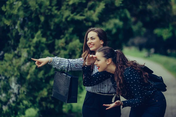 Due belle donne sorridenti e che puntano in strada — Foto Stock