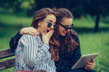 Bir dijital tablet pc ve gülmek kullanarak iki güzel kadın arkadaş