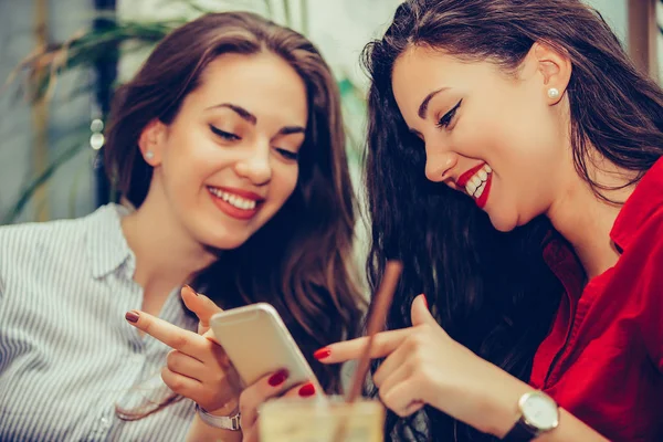 Две счастливые подруги делятся социальными сетями в смартфоне — стоковое фото