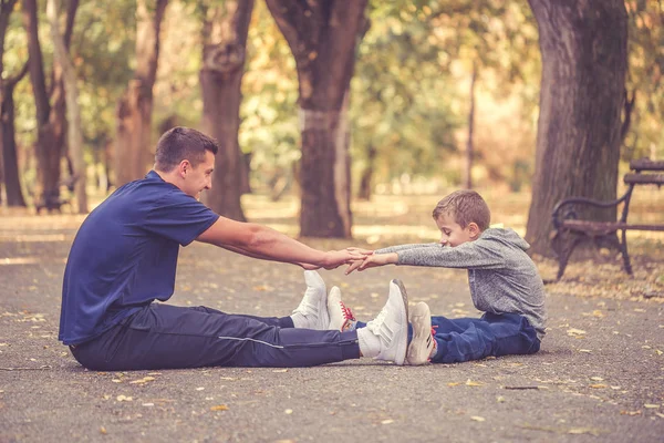 Отец и маленький сын занимаются вместе на открытом воздухе — стоковое фото