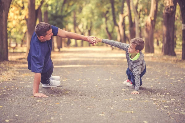 Liten pojke och hans far som utövar tillsammans utomhus — Stockfoto