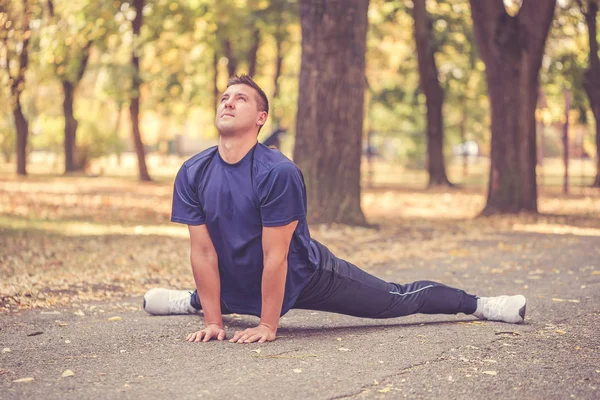 Jovem desportivo fazendo alongamento exercício ao ar livre — Fotografia de Stock