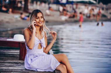 Plajda cep telefonuyla konuşan çekici genç kadın 