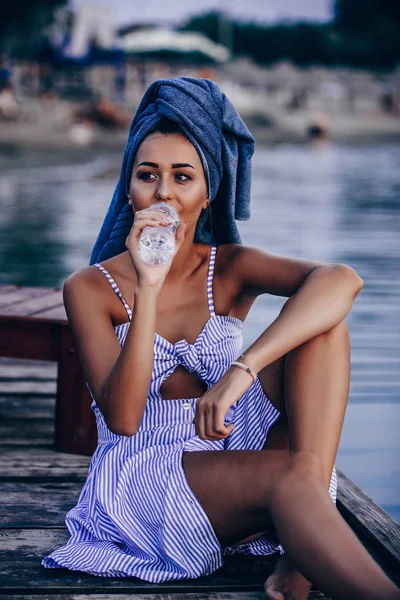 Transpa'dan su içen genç kadın, başında havlu ile