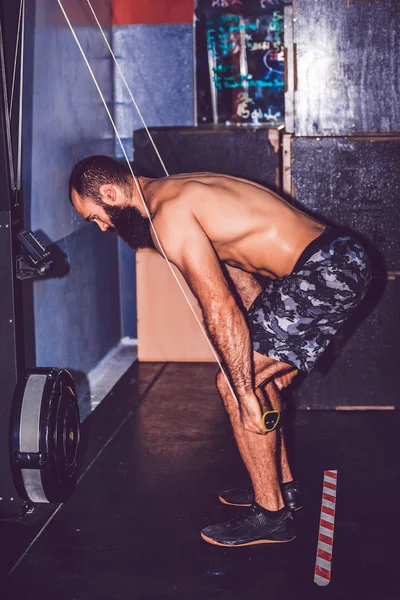 Bearded bodybuilder working out at the gym doing exercises on th — Stock Photo, Image