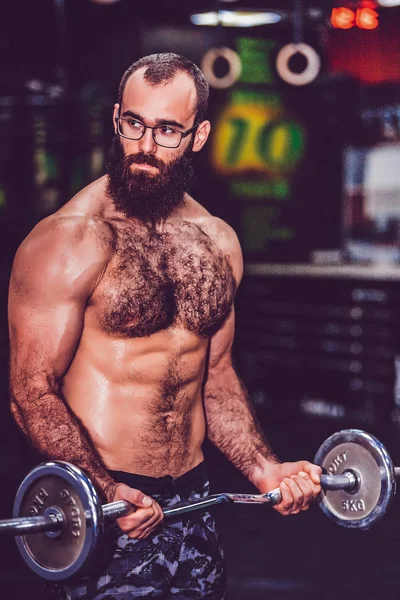 Barbudo haciendo levantamiento de bíceps en un gimnasio — Foto de Stock