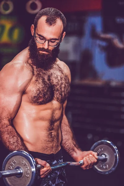 Muskularny Brodaty fitness człowiek trening z Brzana w siłowni — Zdjęcie stockowe