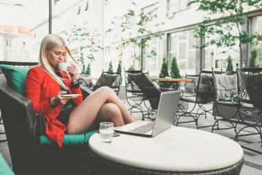 Mutlu genç kadın bir kahve dükkanında kahve içiyor