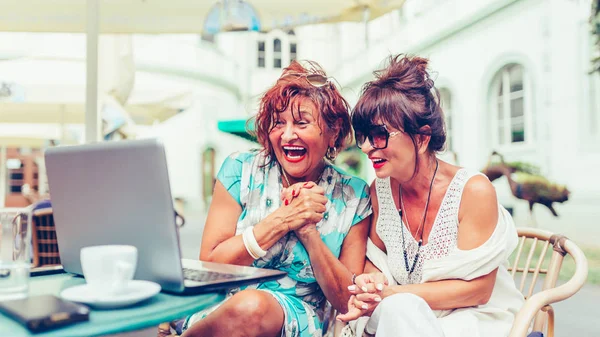 Due donne anziane eccitate leggono buone notizie online sul computer portatile — Foto Stock