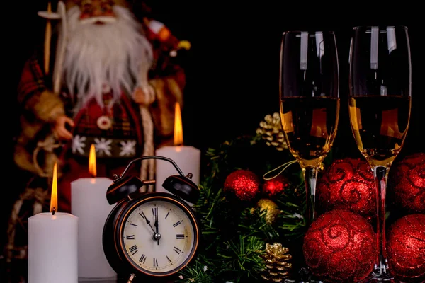 Two wine glasses with champagne, Santa Claus, clock and christma