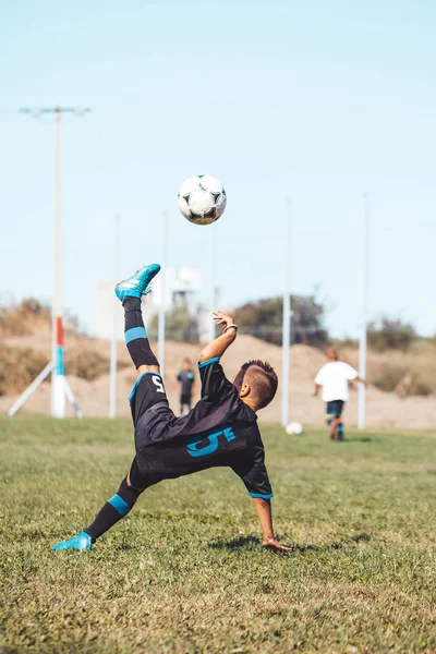 Little boy with soccer ball doing flying kick