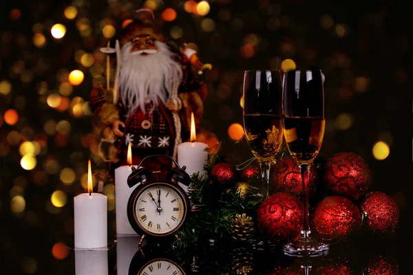 Two wine glasses with champagne, Santa Clause, clock and christm