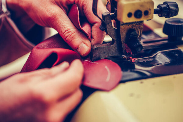 Experienced shoemaker uses a special machine for thinning of the