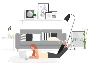 Evde dizüstü bilgisayar kullanan bir kadın yerde yatıyor. 