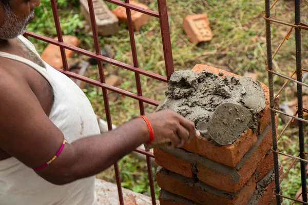 Construction worker creating bricks wall at construction site
