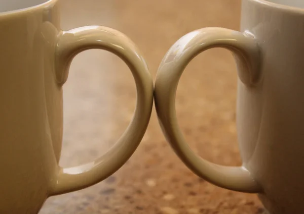 Две Ручки Чашки Кофе Касаются Друг Друга Через Мраморную Столешницу — стоковое фото