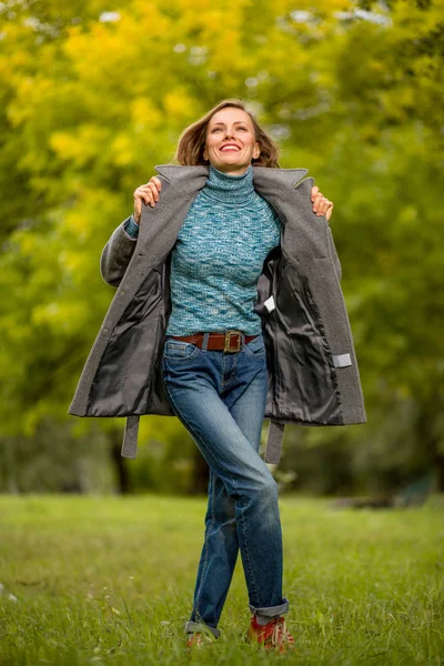 春や秋の日を楽しんで暖かいコートを着て自然の風景でスタイリッシュな女性 — ストック写真