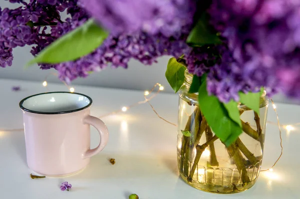 桌子上的丁香花束 有杯子和节日灯 — 图库照片