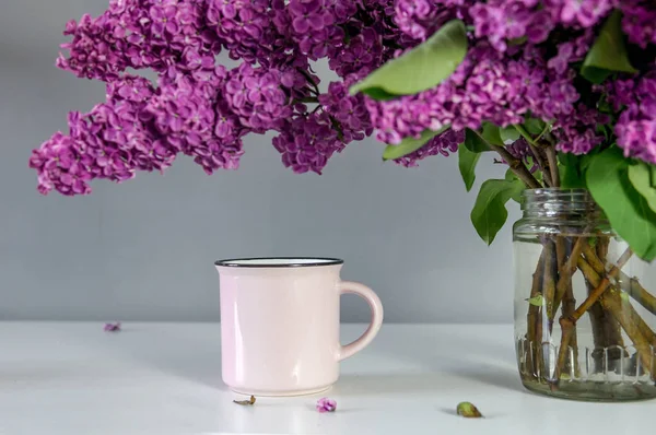 カップをテーブルにライラックの花束 — ストック写真