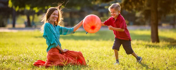 快乐的母亲和儿子在公园外面玩耍 — 图库照片
