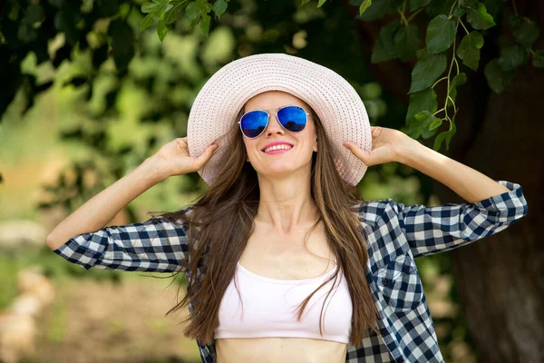 夏の公園でサングラスと帽子を身に着けている美しい女性 — ストック写真