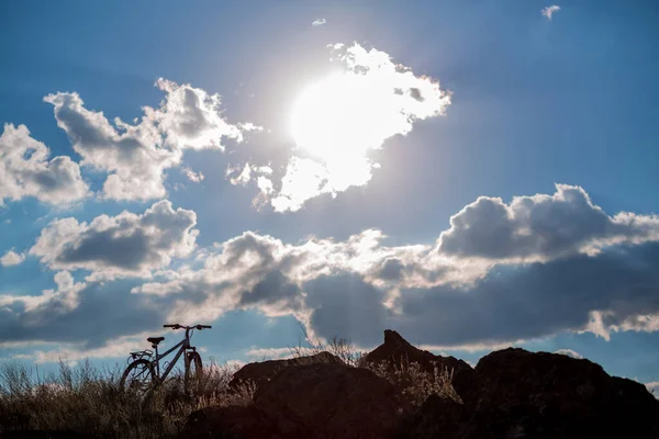 Bir Dağ Bisikletinin Silueti Kayalık Arazide Gökyüzünde Bulutlarda — Stok fotoğraf
