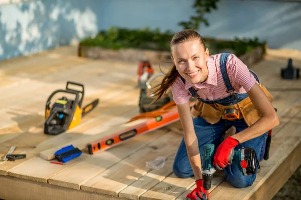 Carpenter woman is at work. Building as a hobby. Beautiful woman with construction tools