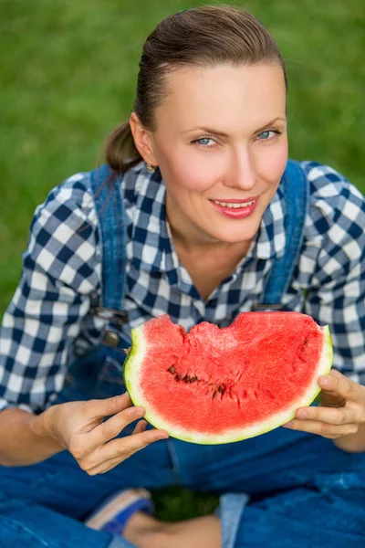 Attraktive Junge Frau Isst Wassermelone Sitzend Über Grünem Natürlichen Hintergrund — Stockfoto