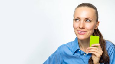 Resmi giysiler içinde genç ve güzel bir kadın. Elinde beyaz bir kart var.