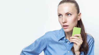 Resmi giysiler içinde genç ve güzel bir kadın. Elinde beyaz bir kart var.