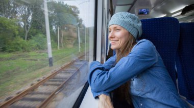 Güzel bir kız trenle seyahat ediyor ve camdan dışarı telefon açıyor.