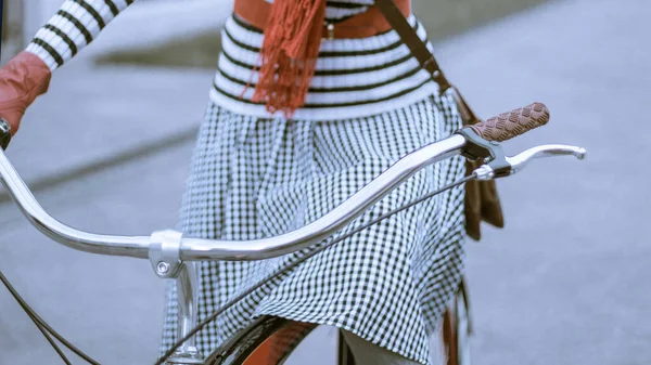 在街上骑自行车的年轻妇女 戴着红色手套 帽子和围巾 — 图库照片