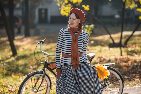 秋天的女子骑自行车在城市公园美丽的秋景中 — 图库照片