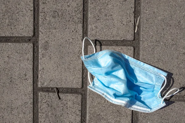 COVID-19 sırasında israf. Sokakta terk edilmiş yüz maskeleri. Çevre kirliliği kavramı