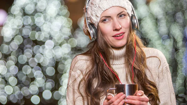 带着耳机和户外热茶的年轻女子冬季肖像 — 图库照片