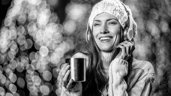 带着耳机和户外热茶的年轻女子冬季肖像 — 图库照片
